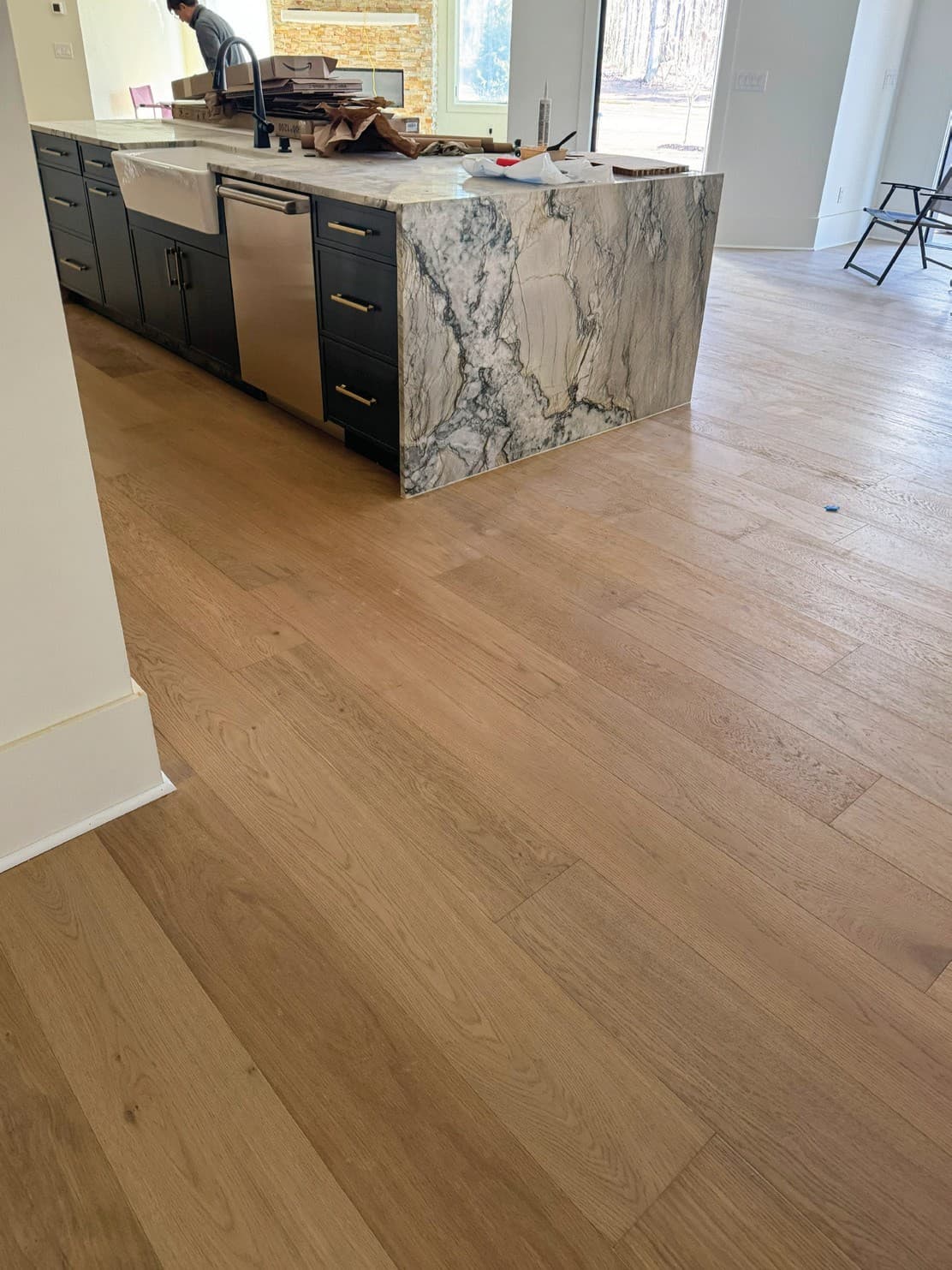 Open concept flooring installation progress in a connected living area.