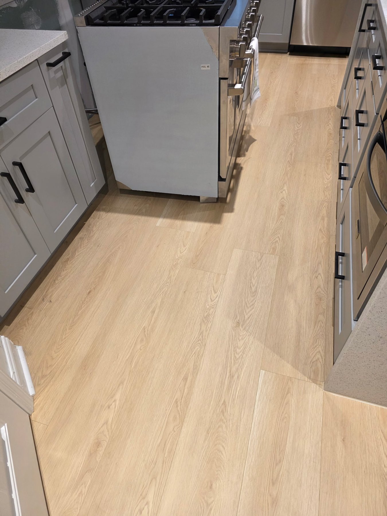 Blonde wide-plank LVP in a luxury Atlanta kitchen with two-tone cabinetry.
